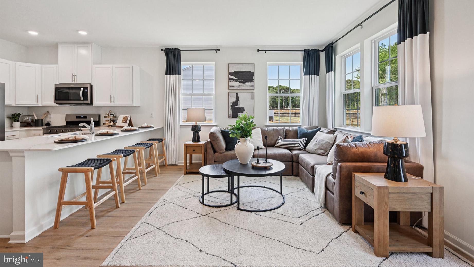 a living room with furniture a flat screen tv and large window