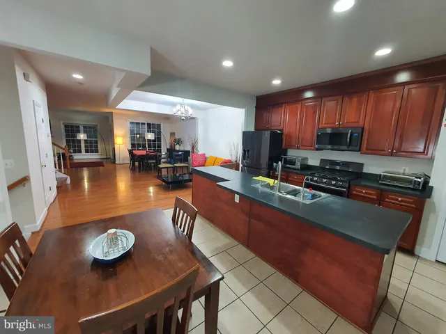 a kitchen with stainless steel appliances granite countertop a sink table and chairs