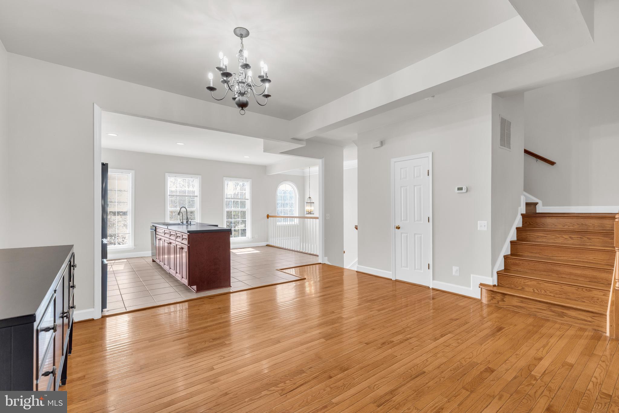 9249 Laurel Ridge Crossing Road Lorton, VA 22079 - Photo 35 of 38 a view of an empty room with wooden floor and a kitchen