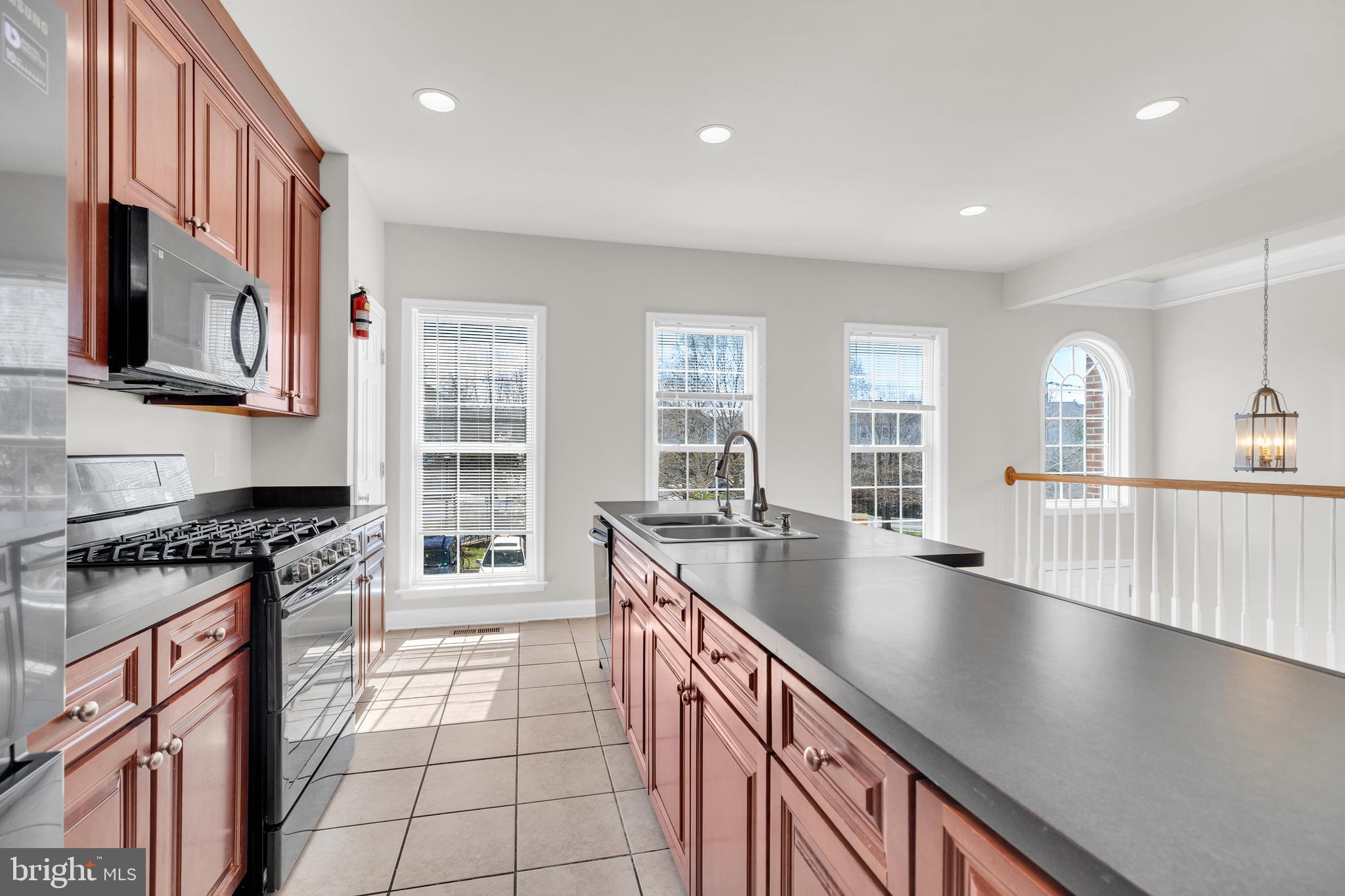 9249 Laurel Ridge Crossing Road Lorton, VA 22079 - Photo 5 of 38 a kitchen with stainless steel appliances granite countertop a sink stove and refrigerator