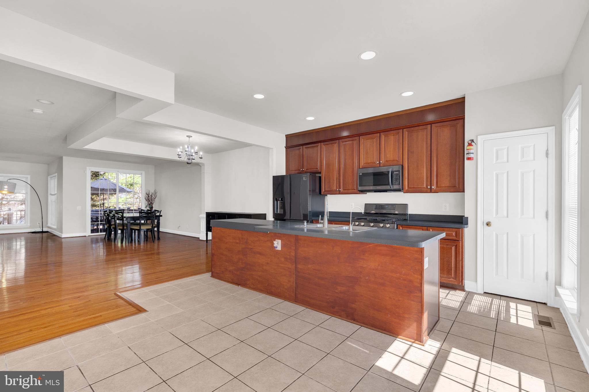9249 Laurel Ridge Crossing Road Lorton, VA 22079 - Photo 6 of 38 a kitchen with stainless steel appliances granite countertop a refrigerator a sink a stove and oven with wooden floor
