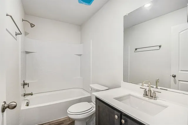 a bathroom with a sink toilet vanity and shower