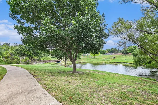 a view of swimming pool with a yard and large trees