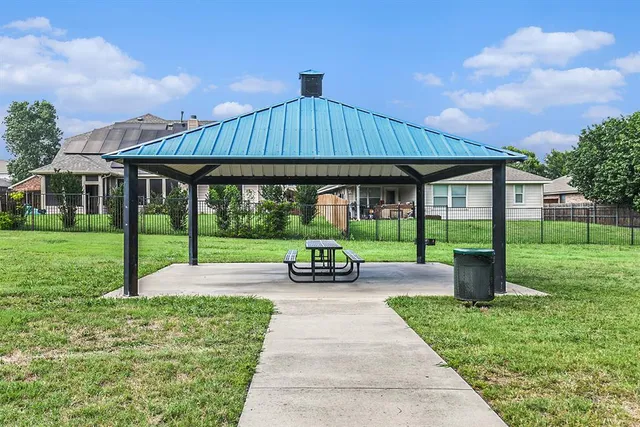 a view of a patio with a table and chairs under an umbrella