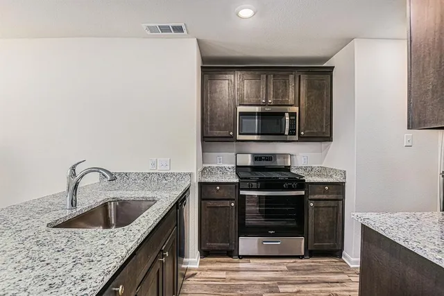 a kitchen with a sink stove and microwave