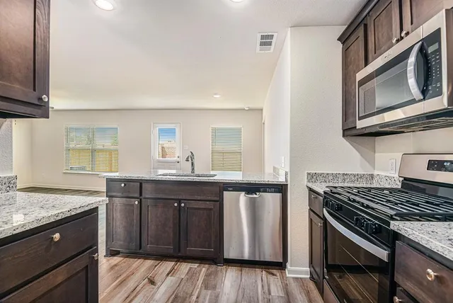 a kitchen with stainless steel appliances granite countertop a stove and a sink