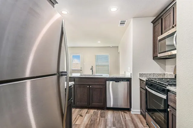 a kitchen with stainless steel appliances a refrigerator and a stove top oven