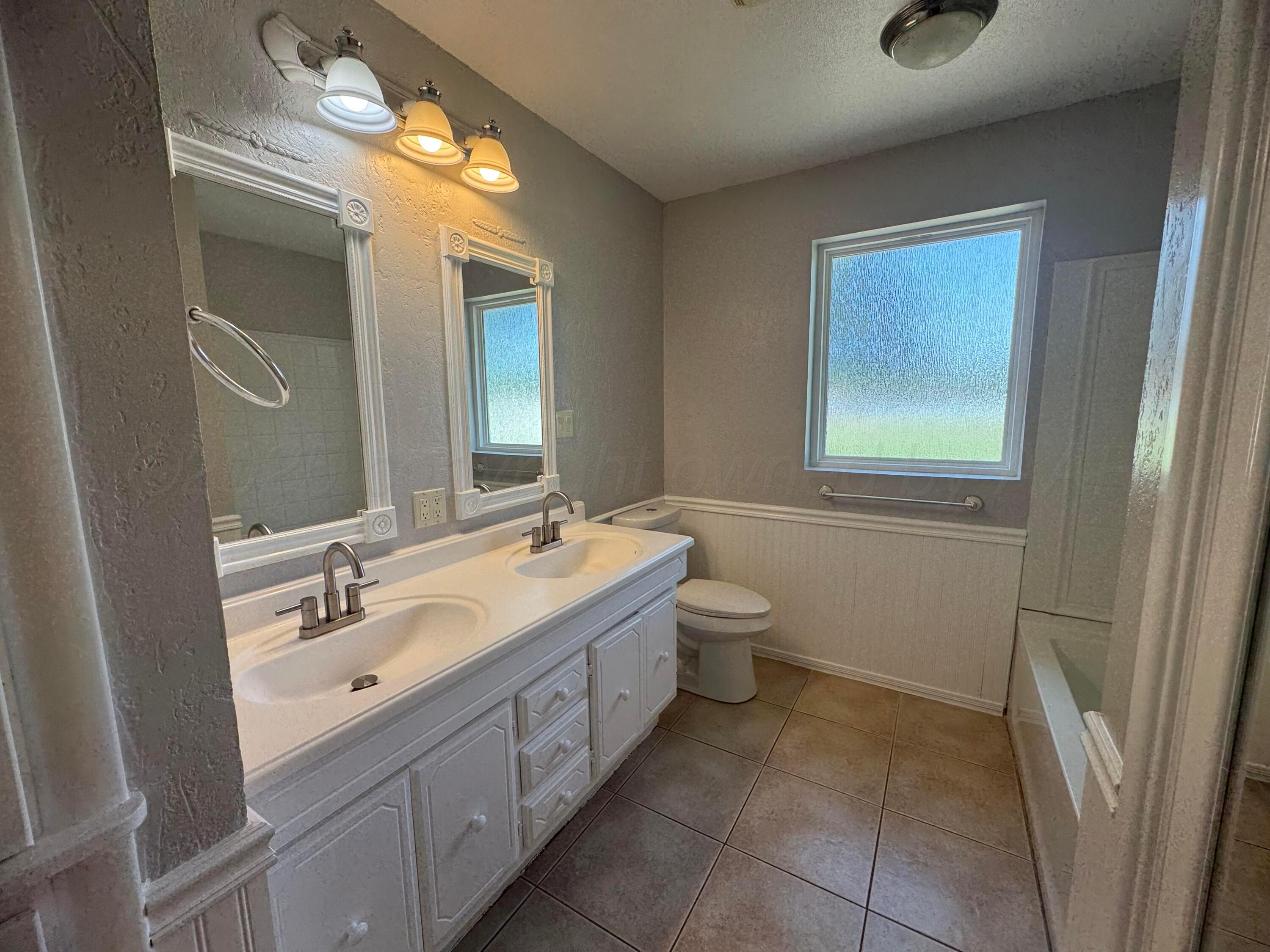 5112 Arden Road Amarillo, TX 79110 - Photo 18 of 28 a bathroom with a double vanity sink and a mirror
