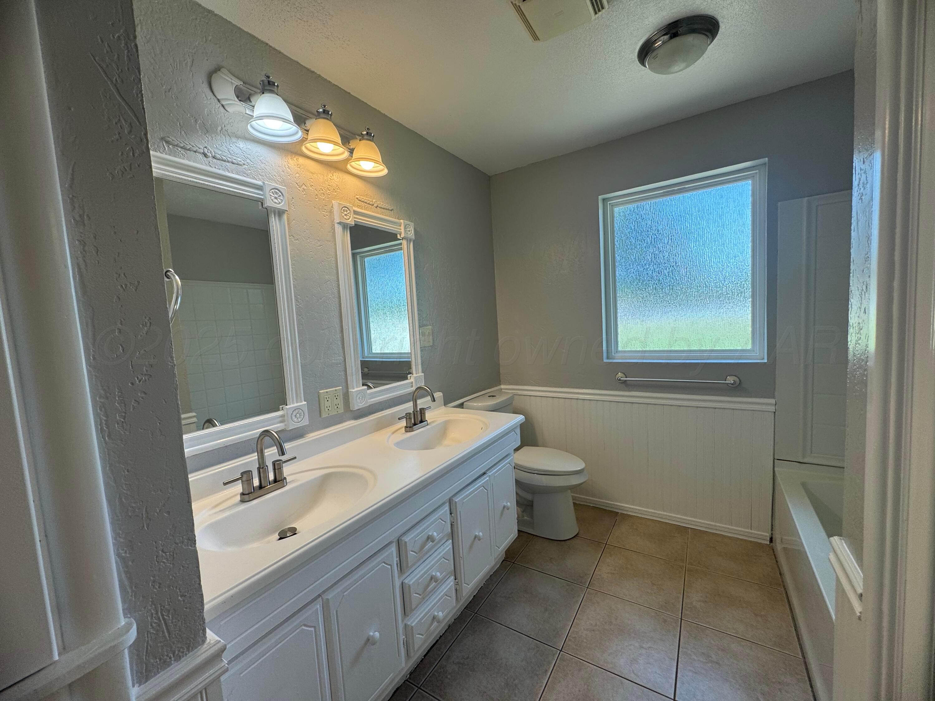 5112 Arden Road Amarillo, TX 79110 - Photo 19 of 28 a bathroom with a double vanity sink and a mirror