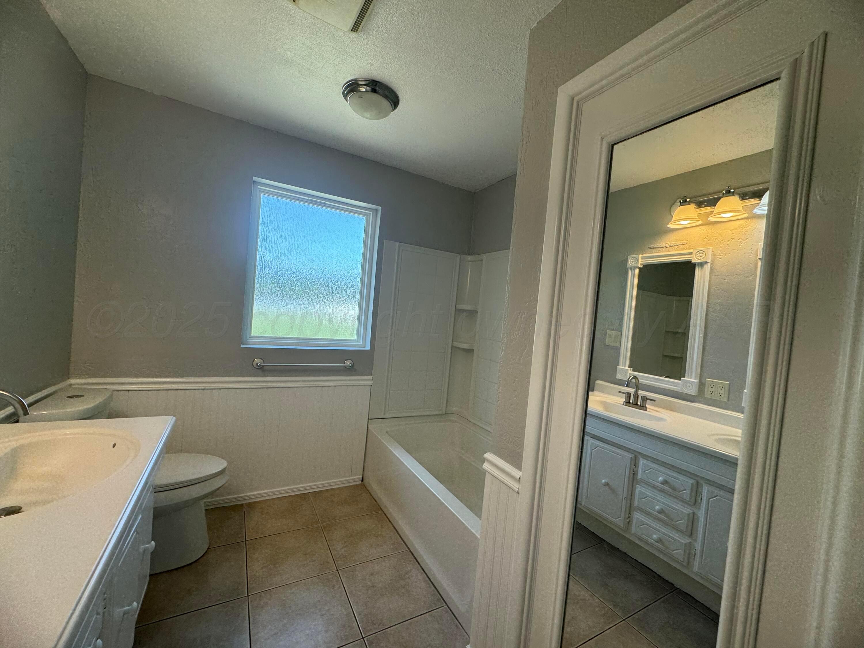 5112 Arden Road Amarillo, TX 79110 - Photo 20 of 28 a bathroom with a sink a toilet and shower
