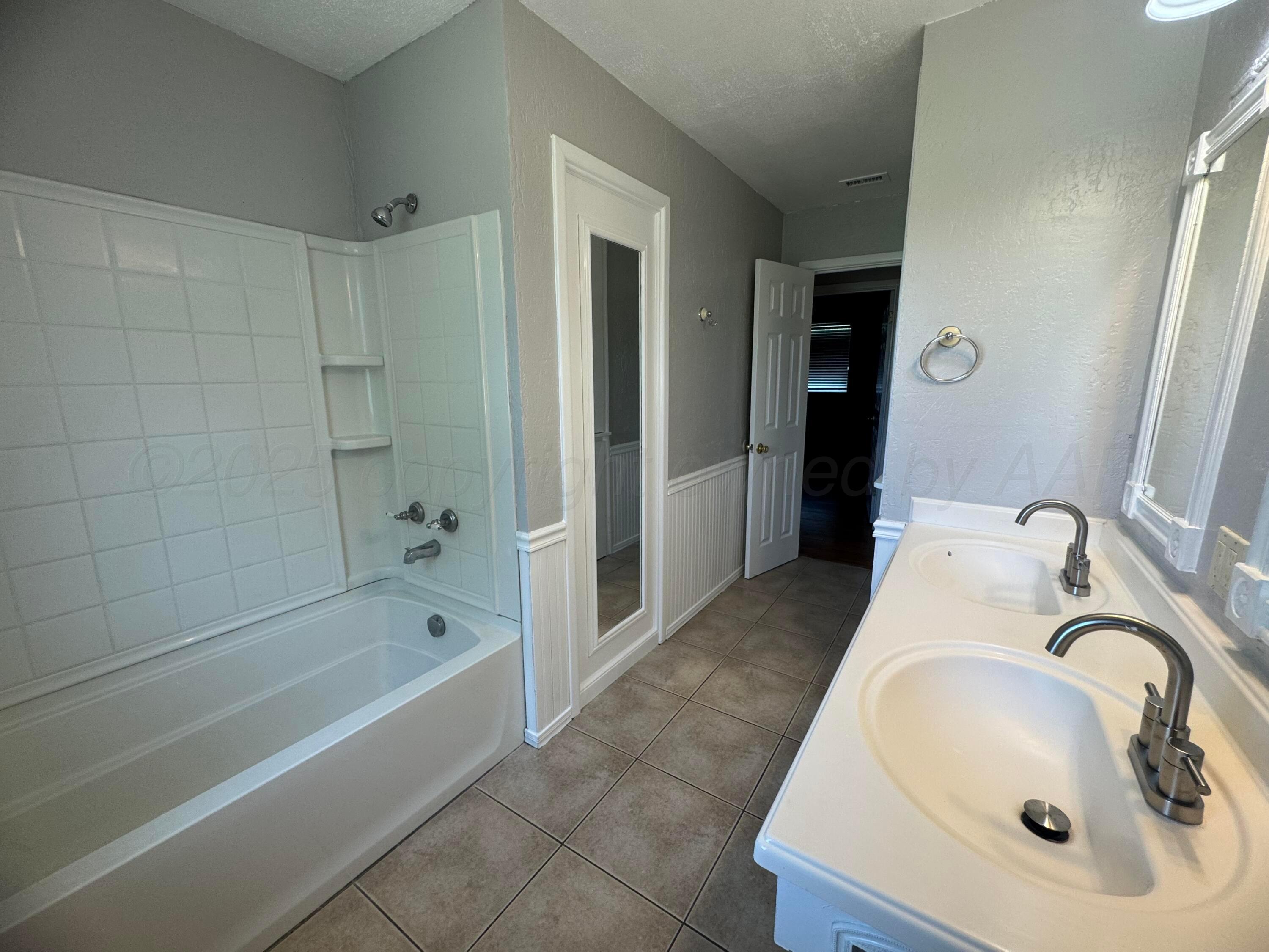 5112 Arden Road Amarillo, TX 79110 - Photo 22 of 28 a bathroom with a tub sink and mirror