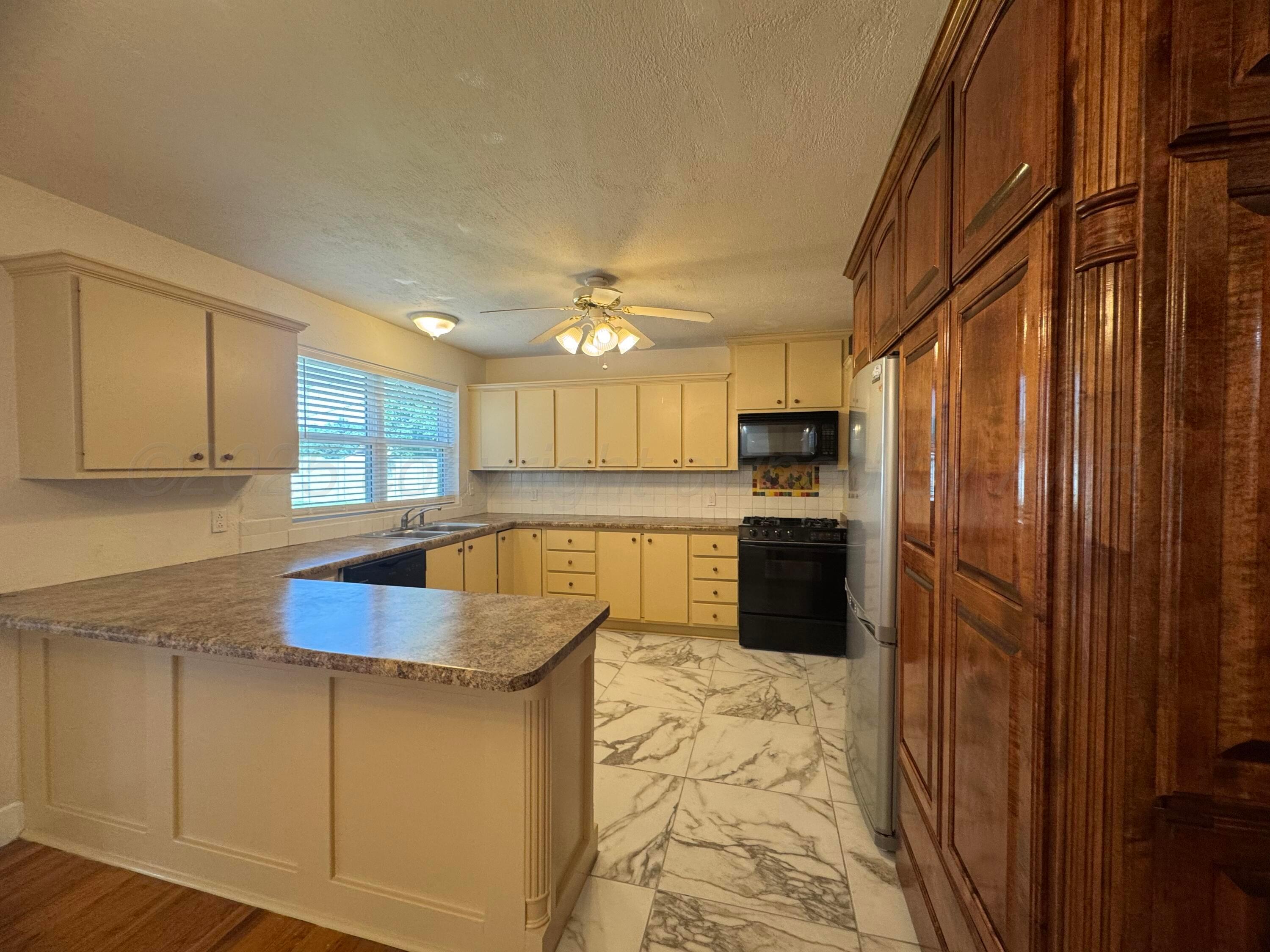 5112 Arden Road Amarillo, TX 79110 - Photo 3 of 28 a kitchen with stainless steel appliances granite countertop a refrigerator sink and cabinets
