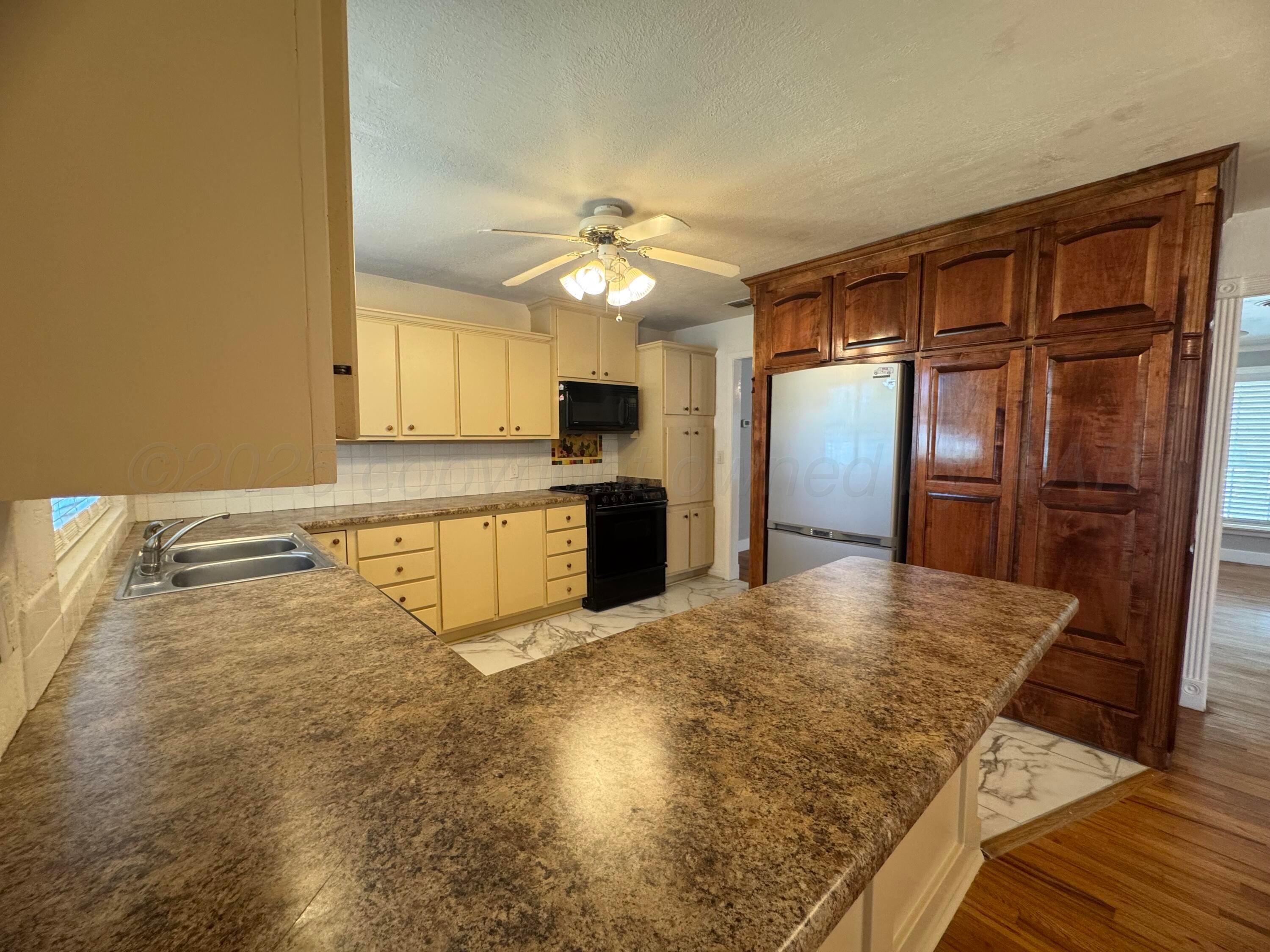 5112 Arden Road Amarillo, TX 79110 - Photo 5 of 28 a kitchen with granite countertop a refrigerator and a sink