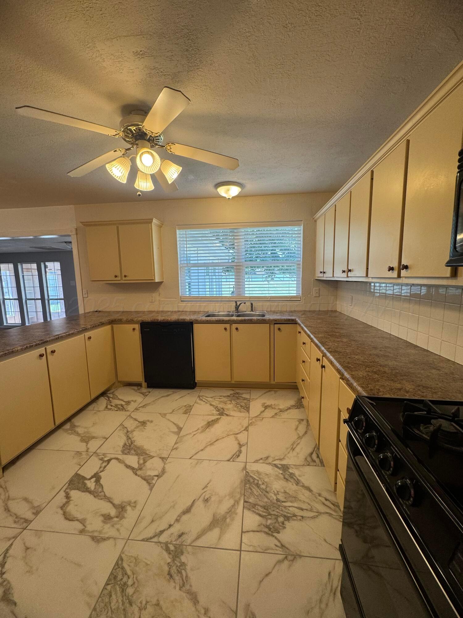 5112 Arden Road Amarillo, TX 79110 - Photo 7 of 28 a kitchen with granite countertop a stove cabinets and microwave