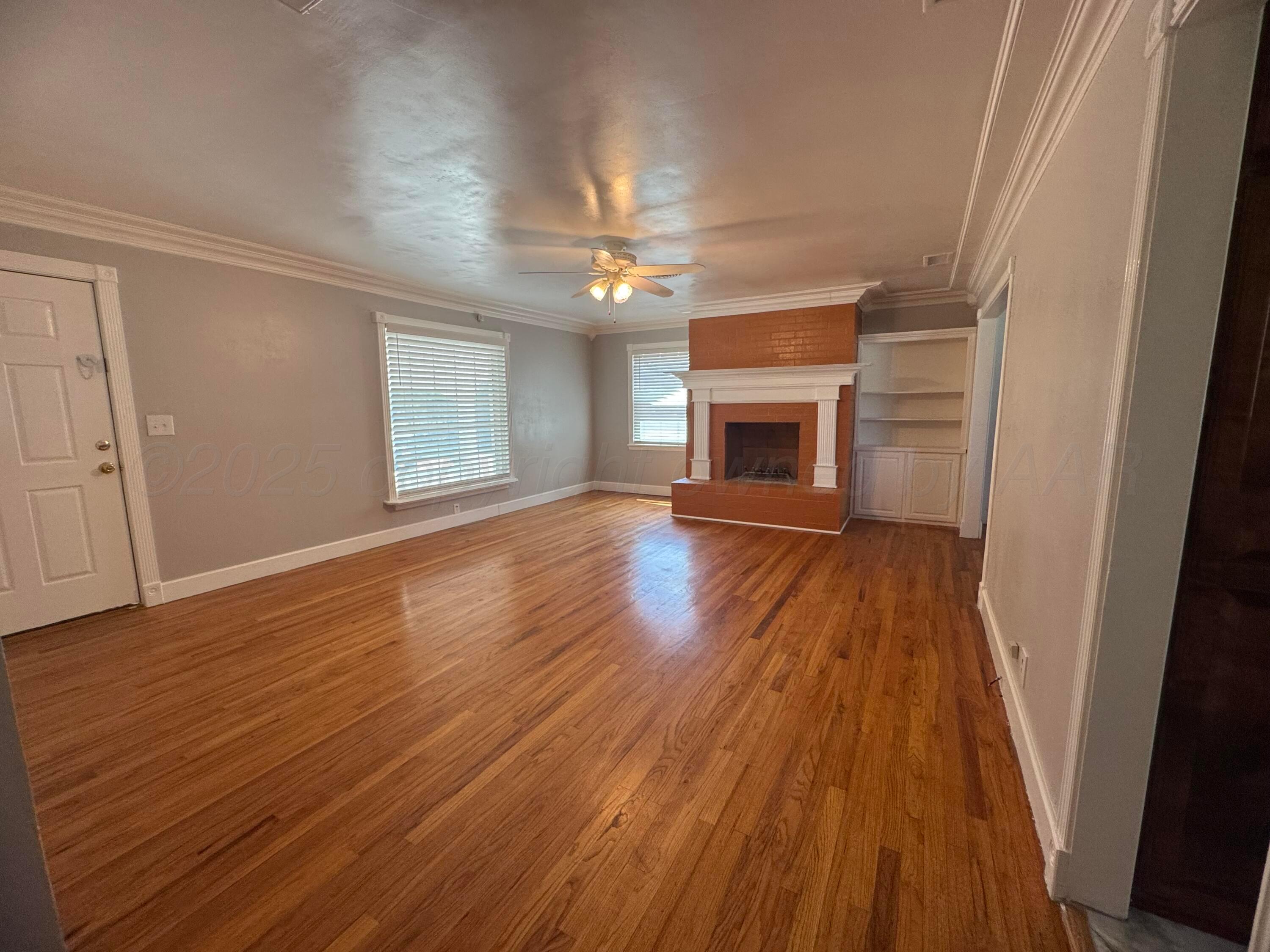 5112 Arden Road Amarillo, TX 79110 - Photo 8 of 28 wooden floor in an empty room with a fireplace