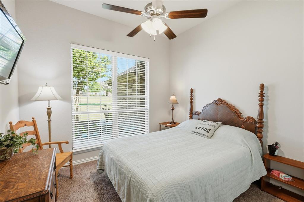 113 Heather Lane Decatur, TX 76234 - Photo 22 of 32 a bedroom with a bed and a chandelier