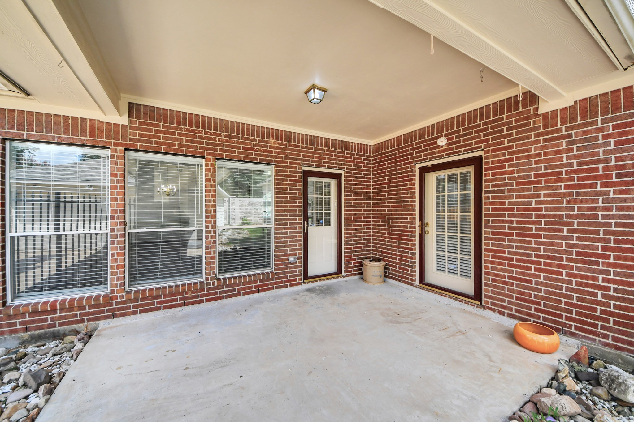 5815 Pheasant Ridge Lane Houston, TX 77041 - Photo 6 of 46 Charming brick patio with ample natural light, featuring dual French doors and large windows, perfect for relaxing or entertaining.