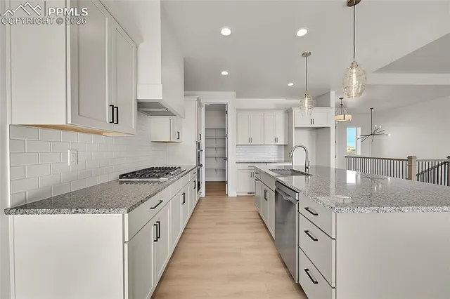 a large kitchen with stainless steel appliances granite countertop a lot of counter space and a sink