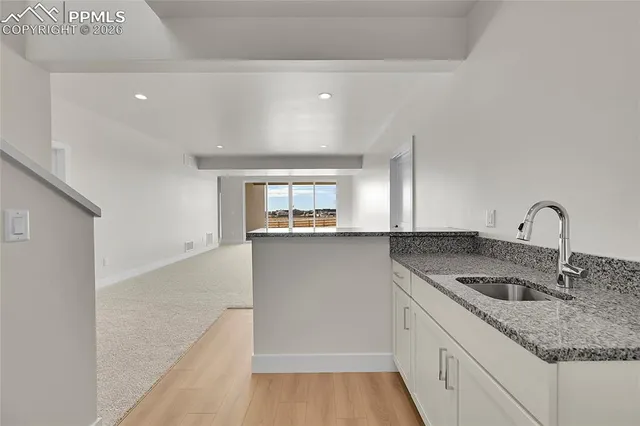 a kitchen with granite countertop a sink and cabinets