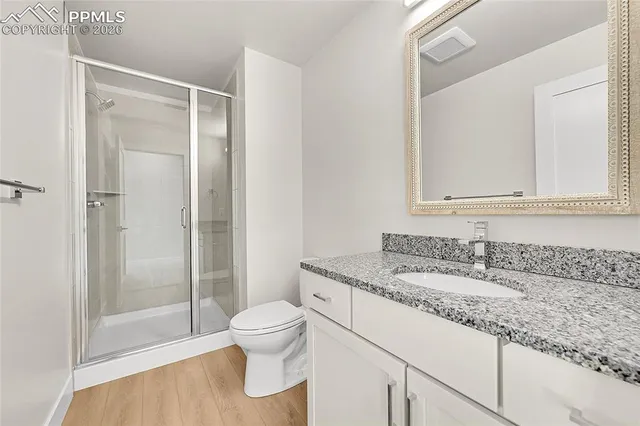 a bathroom with a granite countertop sink toilet and shower