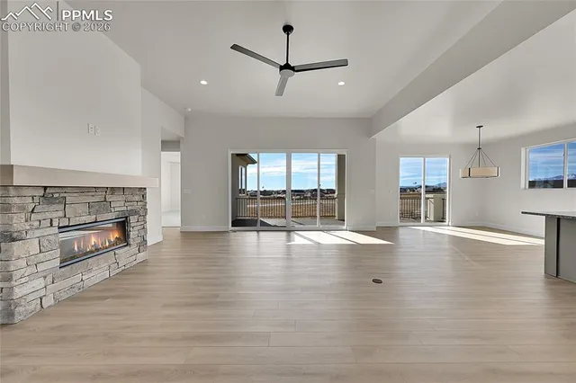an empty room with fireplace wooden floor and windows