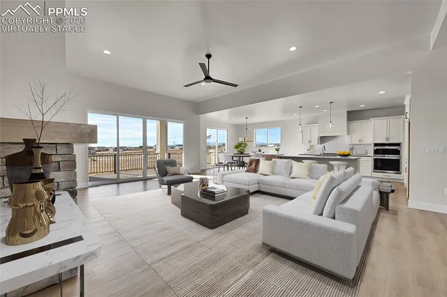 a living room with fireplace furniture and a view of kitchen