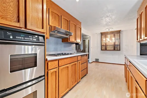 a kitchen with stainless steel appliances granite countertop a stove a sink and a microwave