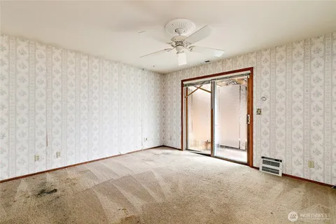 an empty room with fan and windows