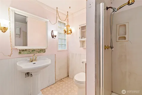 a bathroom with a sink a toilet and shower
