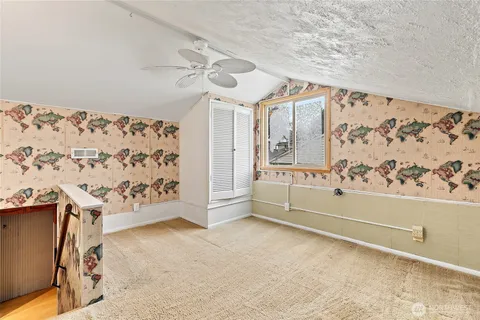 a view of a livingroom with wooden floor and a ceiling fan