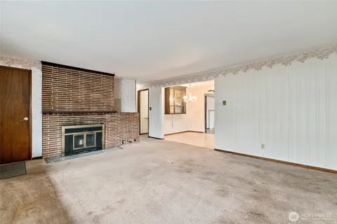 an empty room with fireplace cabinet and windows