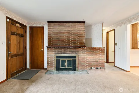 a view of an empty room with a fireplace and a window