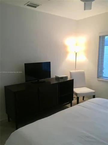 a living room with a bed and a flat screen tv