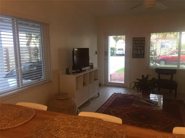 a living room with furniture a window and a flat screen tv