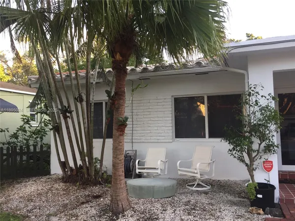 a view of a house with a backyard and a tree