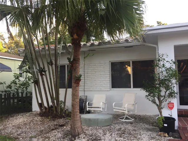 a view of a house with a backyard and a tree