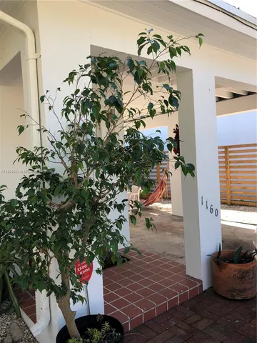 a view of a porch with chairs and potted plants