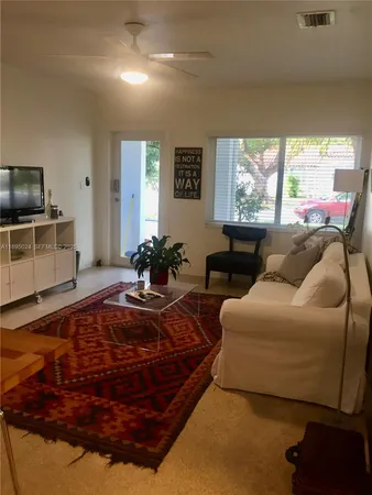 a living room with furniture a large window and a flat screen tv