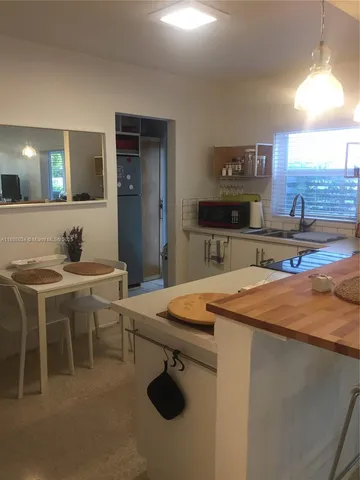 a room with table chairs and wooden floor