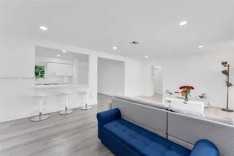 a living room with kitchen island furniture and a wooden floor