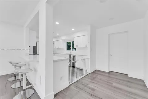 a view of a kitchen with wooden floor and a sink