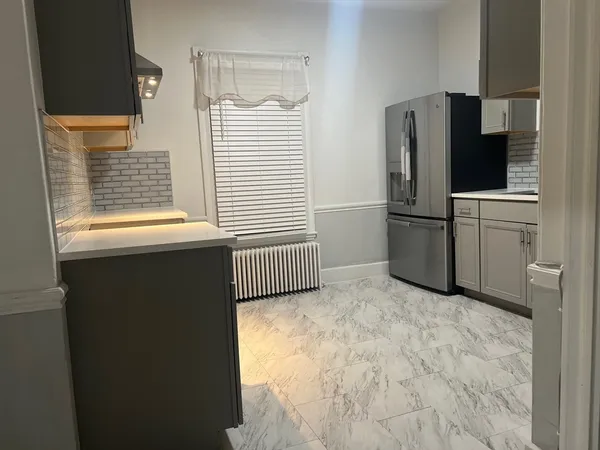 a view of kitchen with refrigerator cabinets and furniture
