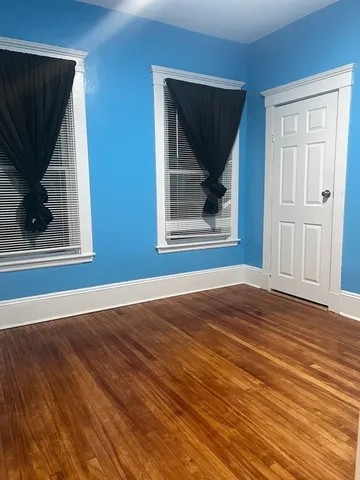 a view of a livingroom with wooden floor and a fireplace