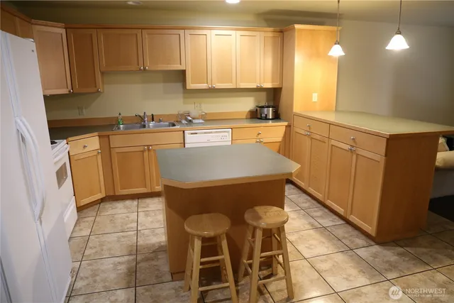 a kitchen with a sink chairs and cabinets