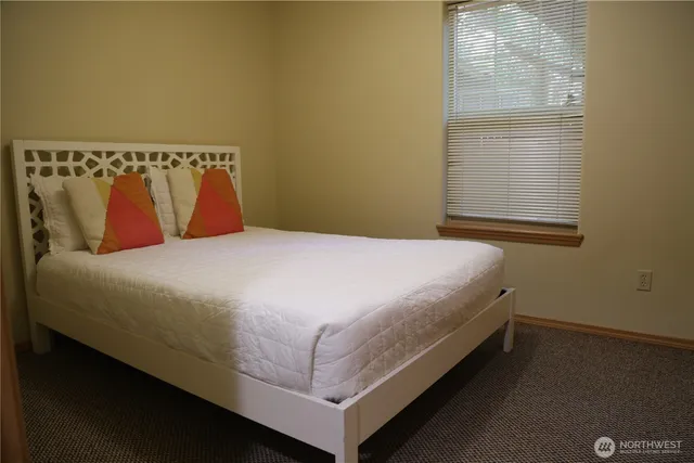 a bed sitting in a bedroom next to a window