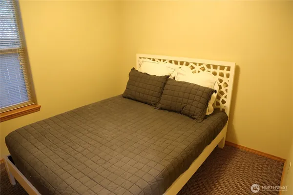 a bed sitting in a bedroom next to a window