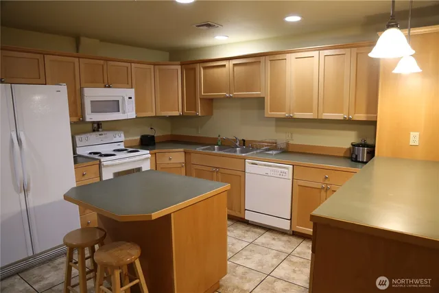 a kitchen with a sink a refrigerator and a stove top oven