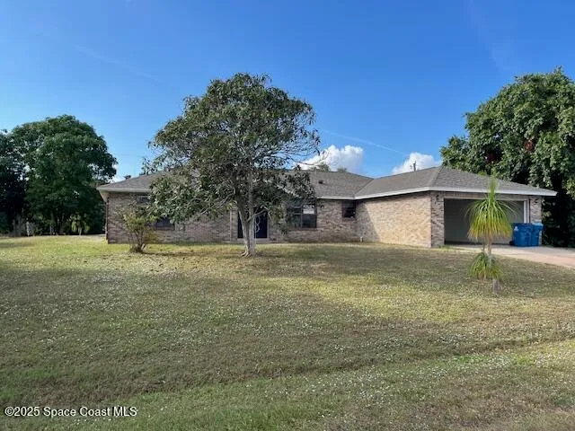 a view of a house with backyard and trees
