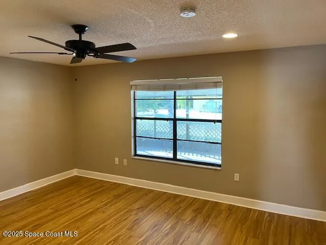 an empty room with a window and wooden floor