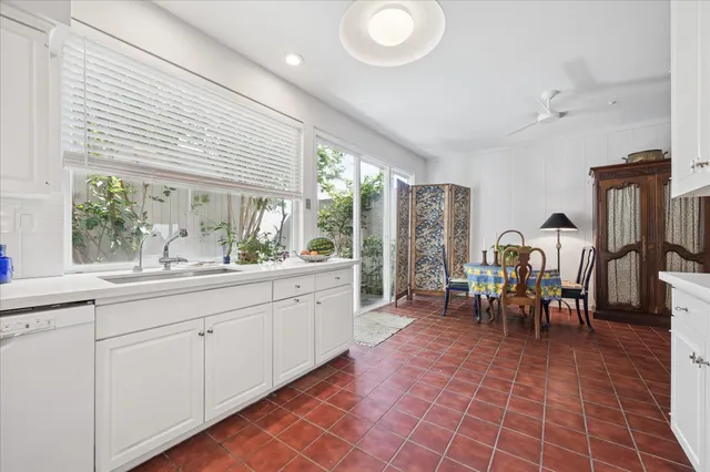 a very nice looking dining room with kitchen island furniture a large window and a sink
